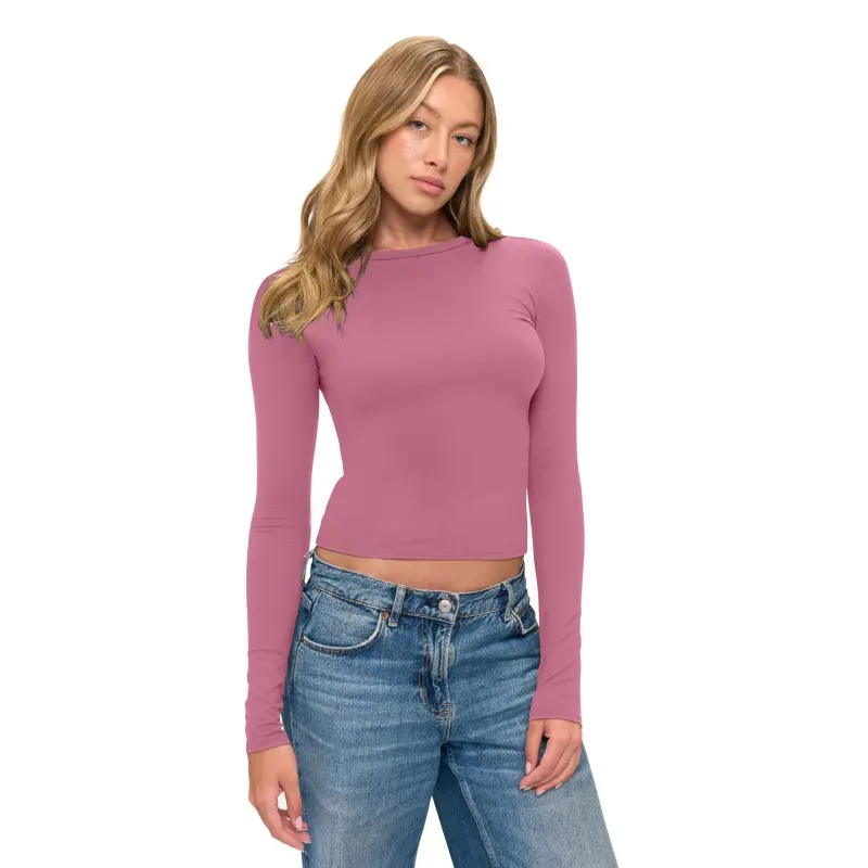 Wholesale women's mauve long sleeve fitted crop top with crew neckline paired with blue denim jeans