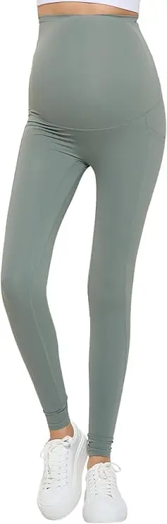 Wholesale maternity leggings in sage green with high waistband and ankle cuffs, paired with white sneakers